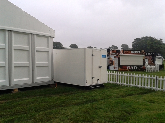 A fleet of Frostbite Refrigeration trailers strategically positioned at a large North West music festival site.